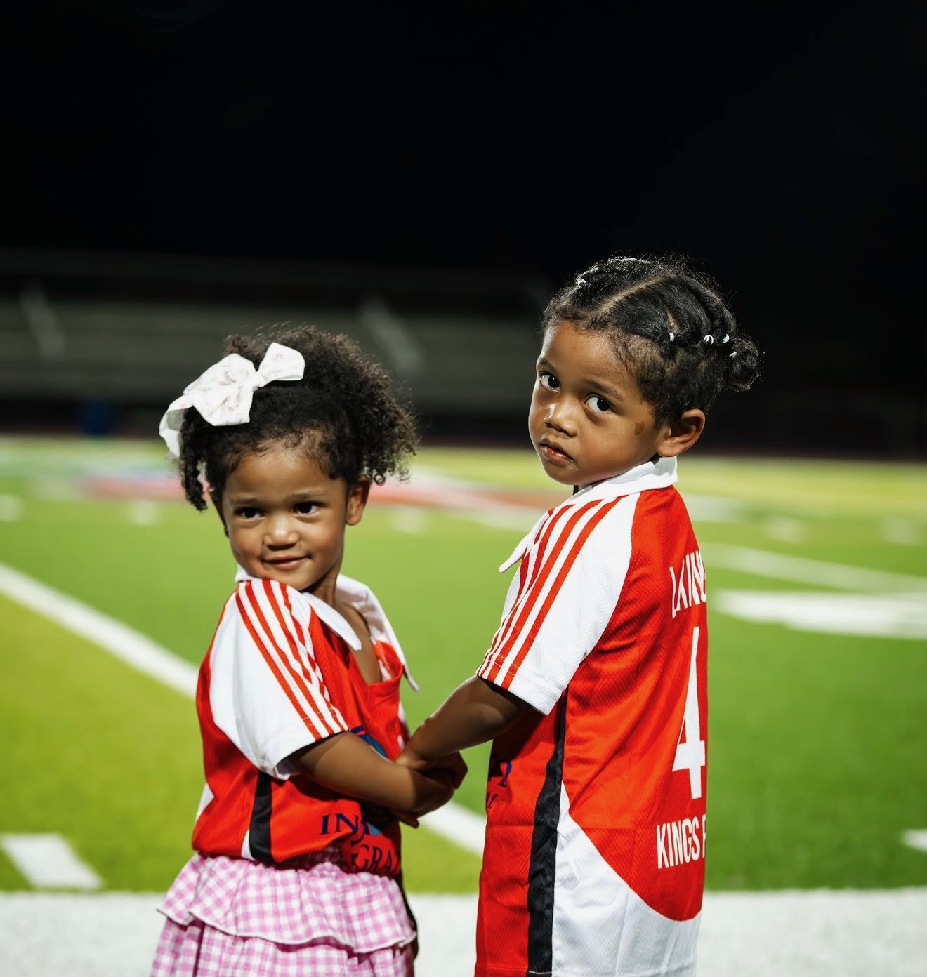 Young Kings FC supporters wearing red and white jerseys.